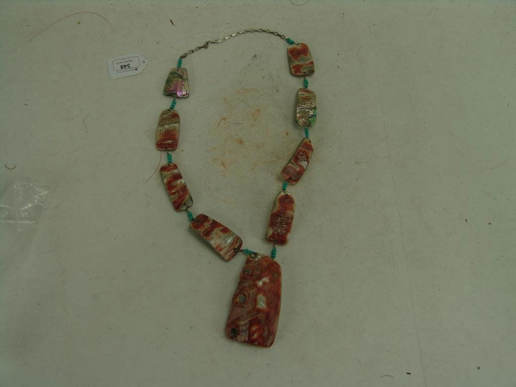 Shell Necklace: Beautiful hand carved Pueblo abalone shell or spondulus shell necklace with large pendant. Retail $900.00. Excellent condition. Circa: Late 1900s Size: 28" long, 3-1/2" x 2" pendant