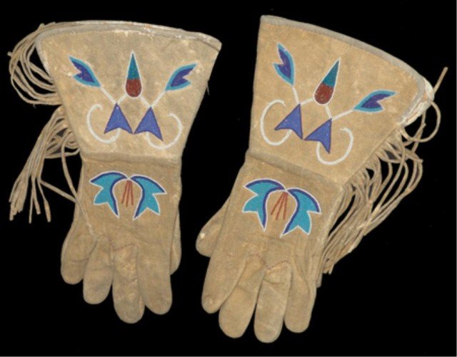 Blackfoot Beaded Gauntlets: Beautiful pair of buckskin gloves with classic florescent beaded forms on the backhands and cuffs. Very good condition, in display frame (optional.) Circa: Early 1900s Size: Men's L/XL (29" x 21" fram