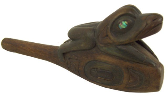 Northwest Coast Child's Rattle: Fine hand carved wooden child's rattle with frog figure having inlaid abalone eyes. Very good condition but splitting on one side. Circa: 1970s Size: 7" x 3" x 1-1/2"