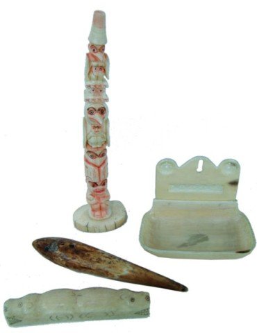 4 Eskimo/Northwest Coast Ivory Items: A 7" Tlingit totem pole, an ulu handle with scrimshaw, a hanging soap holder, and a fossilized lure or plumb bob. Very good condition. Circa: Early/Mid 1900s Size: Various