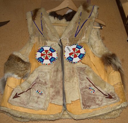 Beaded Vest: Hand crafted shearling vest with beaded rosettes and leather trim and painted skull on the back. Size: Mens large