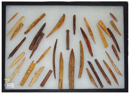 Eskimo Bone Artifacts: Various, Large riker mount filled with old excavated bone (a few of wood) awls, and other tools. 12" x 16"