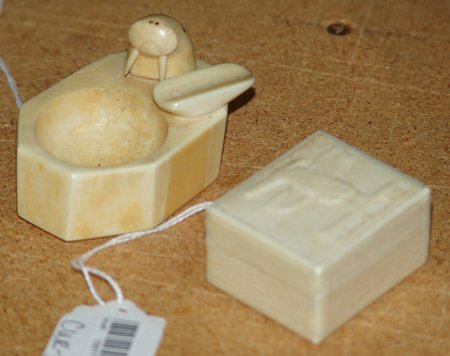Eskimo Ivory Carvings: Pair of very fine Eskimo ivory carvings; one small pill box with a thunderbird on it, one small ashtray with walrus. Both in good condition. Box 1-7/8" + 1-1/2" x 1"
