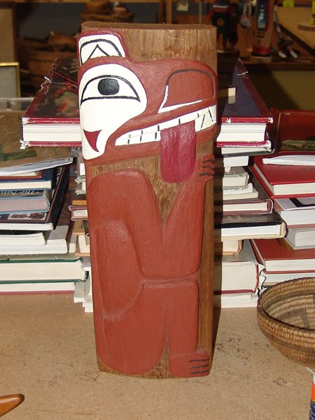 NWC Totem Figure: Hand carved northwest coast panel with a seated bear, signed John Dandal. 16" x 6"