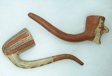 2 Pueblo Pipes: Early 1900s, Pair of early 1900s Pueblo (Isleta?) pipes, one with human face. Both in very good condition, except the striped one has a repair to the mouthpiece. Approximately 6-1/2" x 2-1/4"