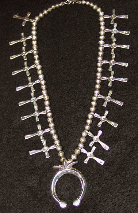 Navajo Necklace - F.L. Begay: Ca. 1980s, Beautiful petite-sized hand wrought all-silver squash blossom-style necklace adorned with crosses and a nice sand cast horseshoe naja. Very good condition, excellent silverwork. 22" long, n