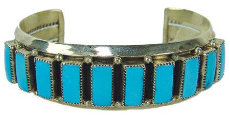 Navajo Bracelet - Raymond Etsitty: Late 1900s, Beautiful all-silver cuff bracelet set with ten hand cut rectangular turquoise stones. Very good condition. 5" + 1-3/8" x 7/8"