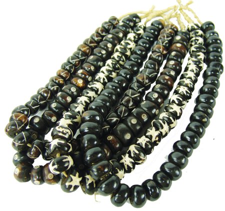 Antique Tradebeads: Late 1900s, Four strands of hand carved African bone beads, each with a custom wooden insert and all in different patterns, including one rare black strand. Very good condition. 26"
