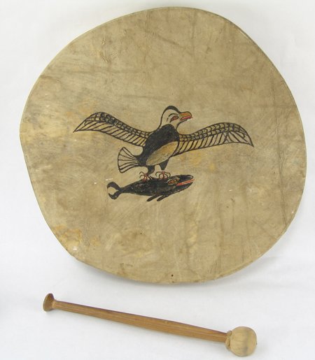 NWC Drum: Ca. 1930, Hand crafted bentwood and rawhide gaming drum with eagle and salmon figures. Good usable condition, has one broken strap on the back. Includes original beater. Collected in Centralia, Washin