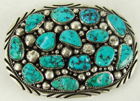 Navajo Belt Buckle - Timothy Lee: Ca. 1980s, Substantial all-silver oval shaped buckle set with 15 beautiful turquoise stones. Very good condition, looks like one stone has been replaced. 2" x 3-3/4"