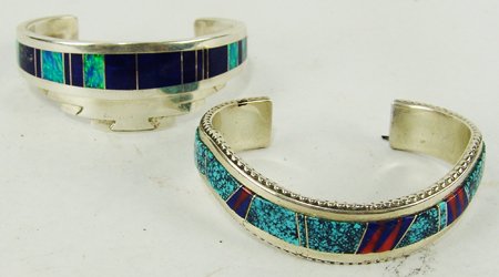 2 Inlay Bracelets: Late 1900s, Both with finely inlaid turquoise, lapis, opaline, and other stones, the straight one hallmarked "P," the curved one by "J. Charley." Very good condition. 5" + 1-1/2" x 1" & 5-1/2" + 1" x