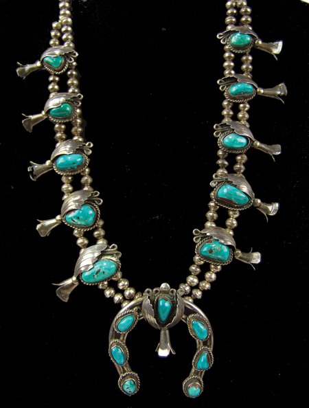 Navajo Necklace: Ca. 1970s, Vintage turquoise and silver "squash blossom" necklace, each of the ten blossoms and naja built with gracefully stamped leaves and nice scroll work. Very good condition, nice patina. 26" lo