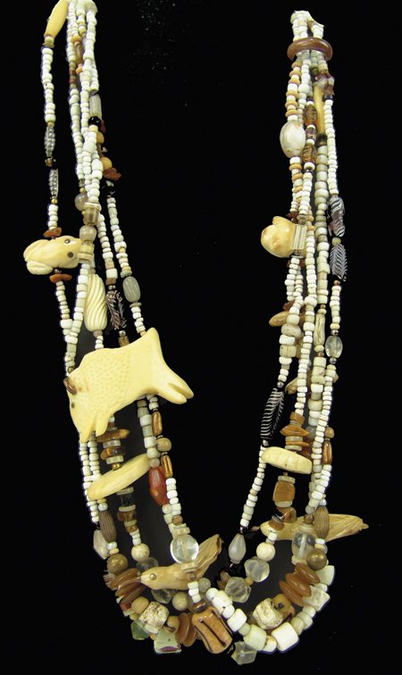Fetish Necklace: Ca. 1980s, Original design four-strand necklace with carved ivory and bone fetishes, plus antique tradebeads and brass ends. Very good condition. 26"