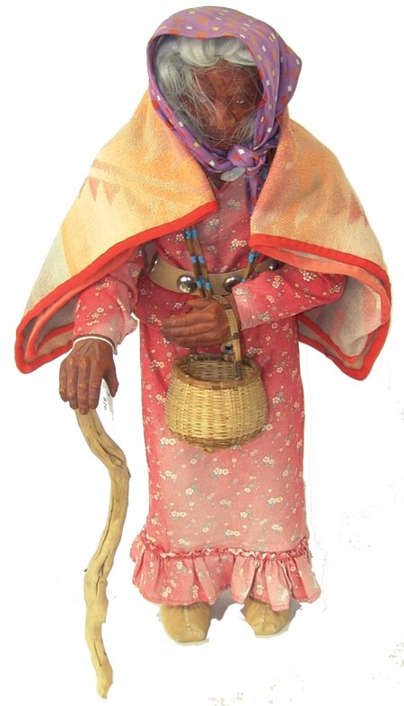 Large Wooden Doll: Ca. 1970s, Vintage wooden doll with finely carved features depicting an old robed woman walking with a cane and carrying a basket. Good condition, faded. 25"