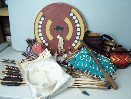 Indian Items: Various Ages, A 19" painted Cheyenne hide war shield with bells, feathers, and medicine bundle; a crossed arrow wall hanging with turtle shell center, medicine wheel, and dream catcher; a Yakima shell