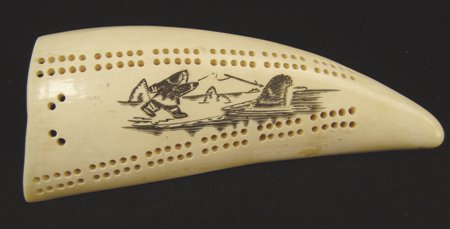 Eskimo Ivory Cribbage Board: Ca. 1970s, Small and portable cribbage board made from whale's tooth, with fine scrimshaw scene on top. Very good condition. Comes with one peg. 2" x 5"