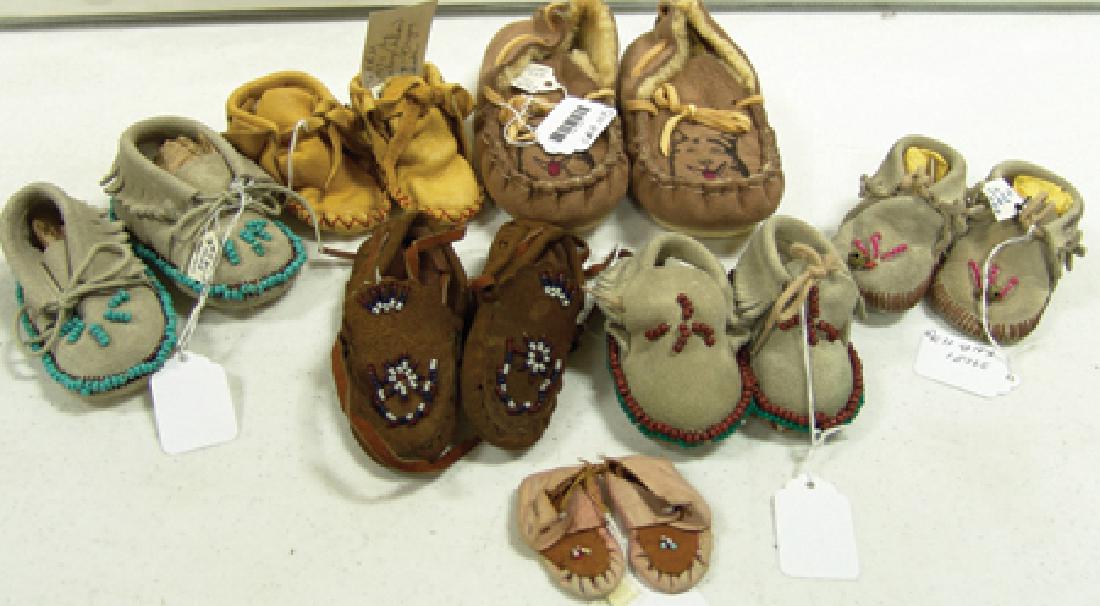 Moccasin Box Lot: Various Ages, Collection of seven pairs of child's or baby moccasins, all in unworn condition. The buckskin pair is dated 1971 and made by Earl Henberg of Roseberg, Oregon. The larger pair has tag tha