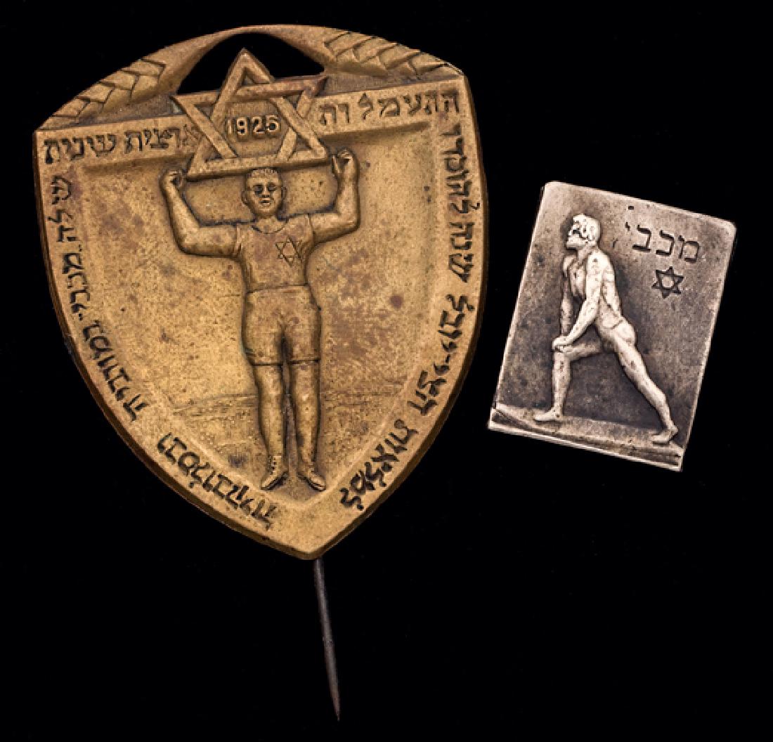 Two Jewish sports pinbacks, The first silvered: Two Jewish sports pinbacks, The first silvered featuring athlete and ''Maccabi'' in Hebrew above Star of David, believed to be Czech late 20s/early 30s; the other larger in gilt, highly detailed athle