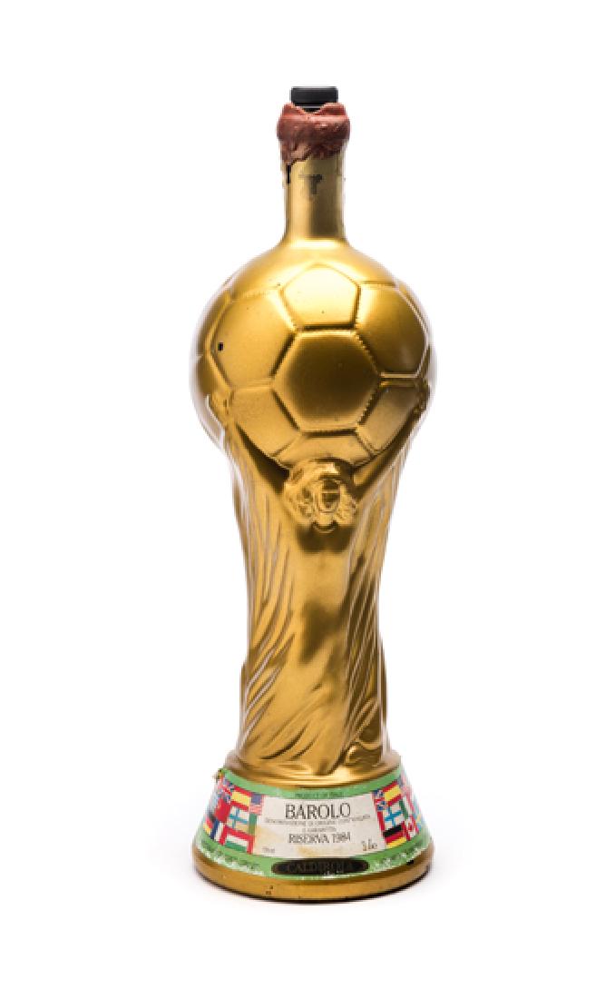 1990 World Cup souvenir wine bottle designed as the: 1990 World Cup souvenir wine bottle designed as the FIFA World Cup Trophy, 3 litres Barola 1984 reserve, paper label bearing the national flags of the competing nations, 49cm.