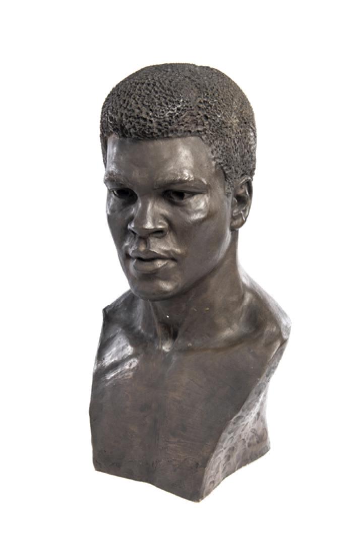 A Limited Edition bronze resin bust of Muhammad Ali by: A Limited Edition bronze resin bust of Muhammad Ali by Sheerlast, bears artist seal to the reverse with monogram DRS, Limited Edition No. 20 of 200, with certificate on the base, height: 44 cm.