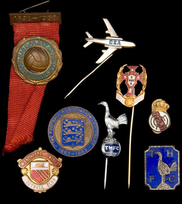 A collection of lapel badges, pin badges and key r