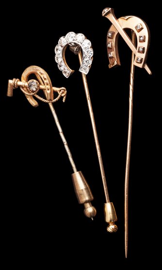 A trio of gold & diamond stick pins with horse shoe: A trio of gold & diamond stick pins with horse shoe designs, with one crossed by a riding crop, an another by a horse shoe nail