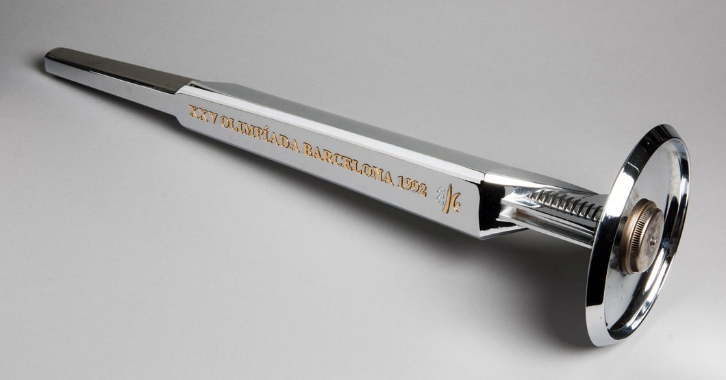 A 1992 Barcelona Olympic Games bearer's torch, designed: A 1992 Barcelona Olympic Games bearer's torch, designed by Andre Ricard, manufactured by Kromschroder, length 68cm. 26 3/4in., weight 1,200gr., evidently modified to be displayed on a wall with drille