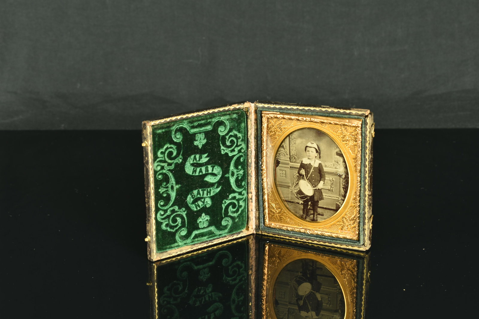 Super Rare 1850's Ambrotype of a 'Little Drummer Boy': This 1850's Ambrotype depicts a young boy posing with a Drum and Helmet. Presented in a fine leather case with green velvet and meticulously chased gold metal frame marked - 'A.P. Hart, Bath, New York