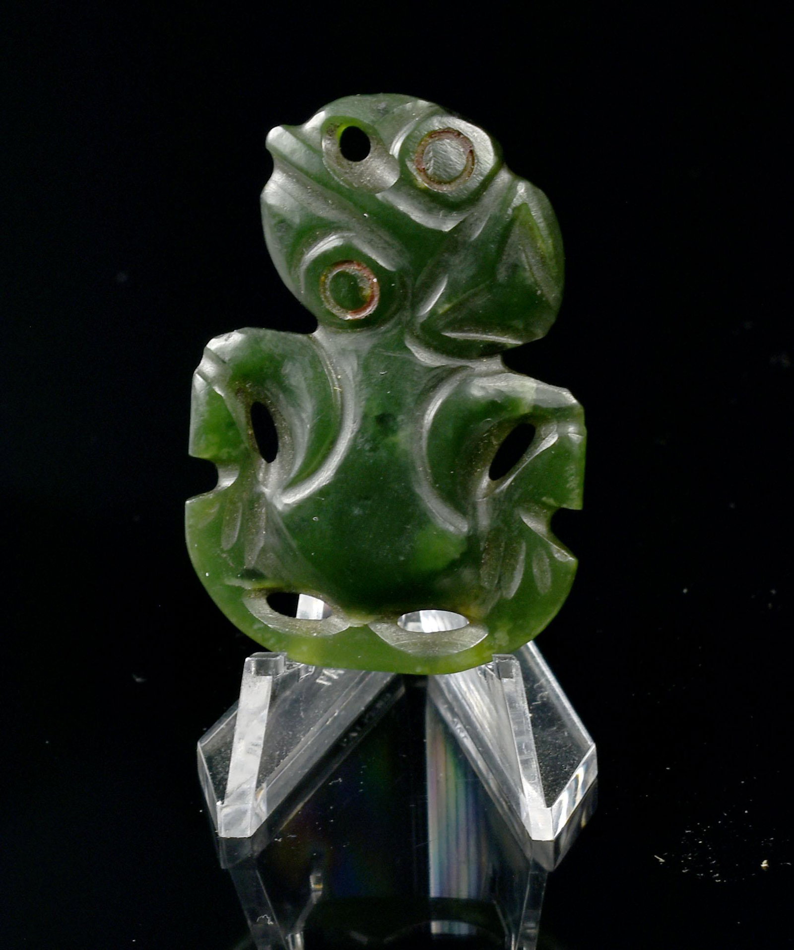 Antique Maori Jade Tiki Pendant from New Zealand: Antique Maori Jade Tiki Pendant from New Zealand circa 1890 AD. The tilted head is carved with large circular eyes with remains of red wax. Drilled though the forehead for suspension