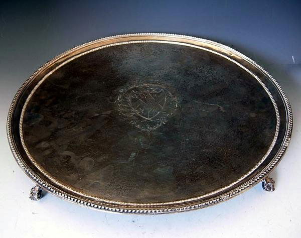 G 111 SILVER SALVER: A George III silver salver by Robert Jones, London 1781, of plain circular shape with beaded edge, engraved with an armorial, raised on four ball and claw supports, 40.5cm diameter, 55oz