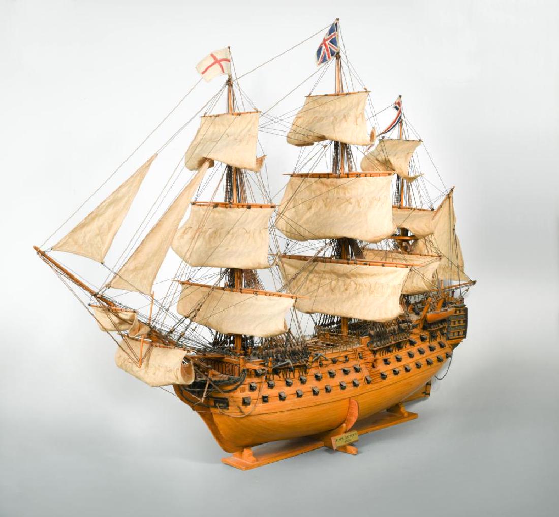 HMS Victory', a wooden model ship,: HMS Victory', a wooden model ship, with full rigging, mounted to a stand with brass plaque 75 x 100cm (29 x 39in)