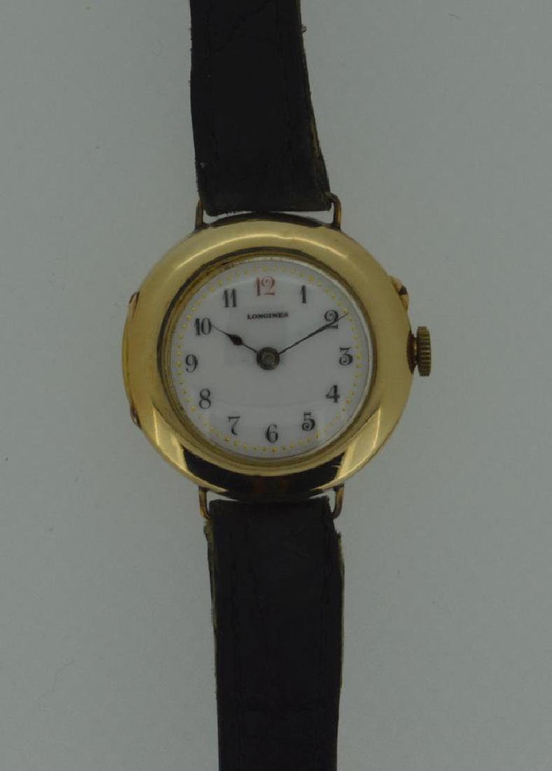 Longines - A lady's 9ct gold wristwatch,: Longines - A lady's 9ct gold wristwatch, circa 1912, the circular signed white enamel dial, 20mm diameter, with black Arabic numerals (number 12 in red), gold coloured dot minute track and blued hands