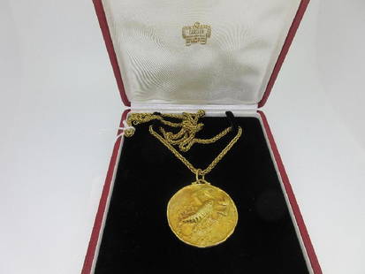 Cartier - An 18ct gold zodiac medallion and chain in: Cartier - An 18ct gold zodiac medallion and chain in the original case, the cast medallion representing Scorpio, London hallmarks for 18ct gold, 1977 and signed 'Cartier', 5.1cm diameter; to a spiga l