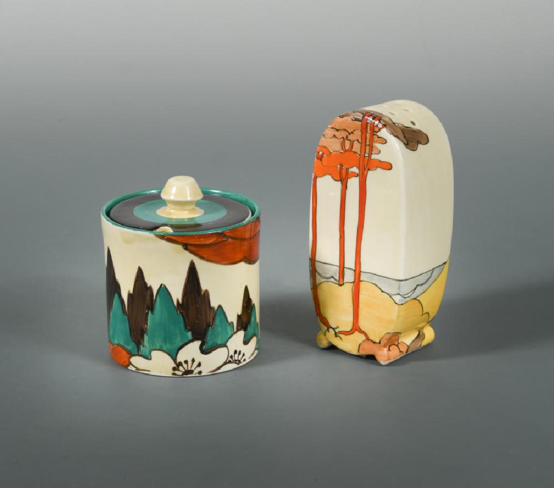 A Clarice Cliff Coral Firs pattern sifter,: A Clarice Cliff Coral Firs pattern sifter, in the Bonjour shape, together with a Clarice Cliff Limberlost pattern preserve jar and cover, of cylindrical form, printed factory marks and Lawleys retail