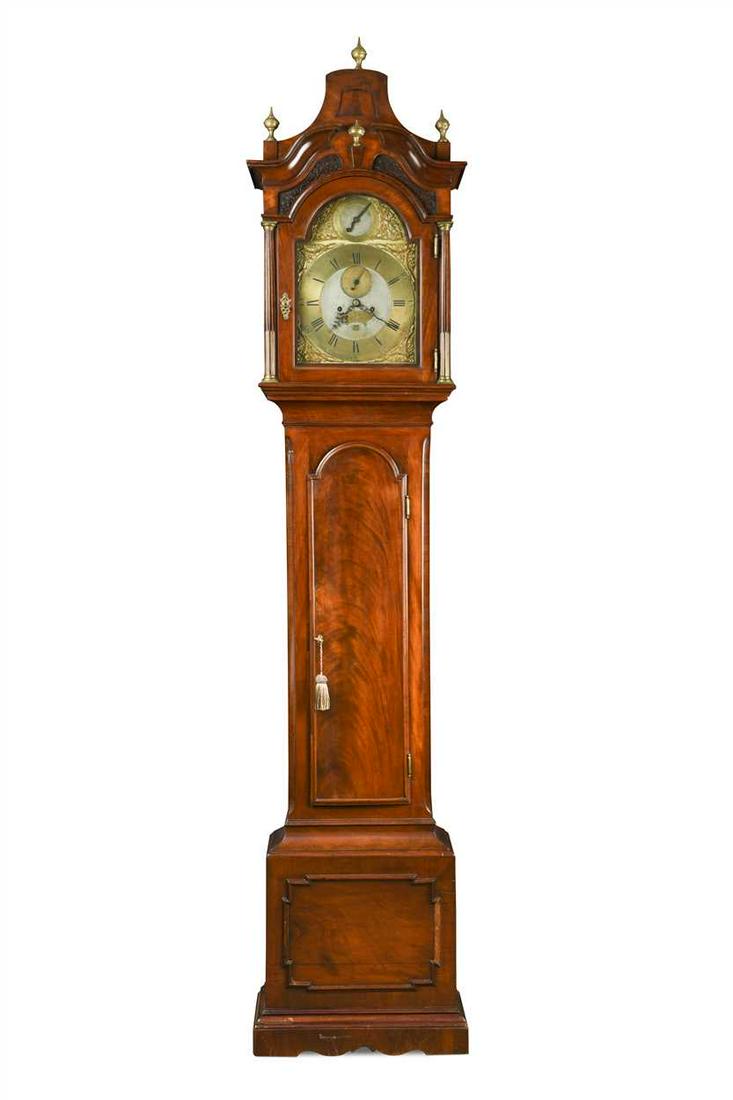 A George III mahogany longcase clock,: the break arch hood with 12 inch brass dial signed 'John Taylor London', Rococo spandrels, inset seconds dial and date aperture, with 5 pillar movement, all on a rectangular plinth base (Dimensions: 2