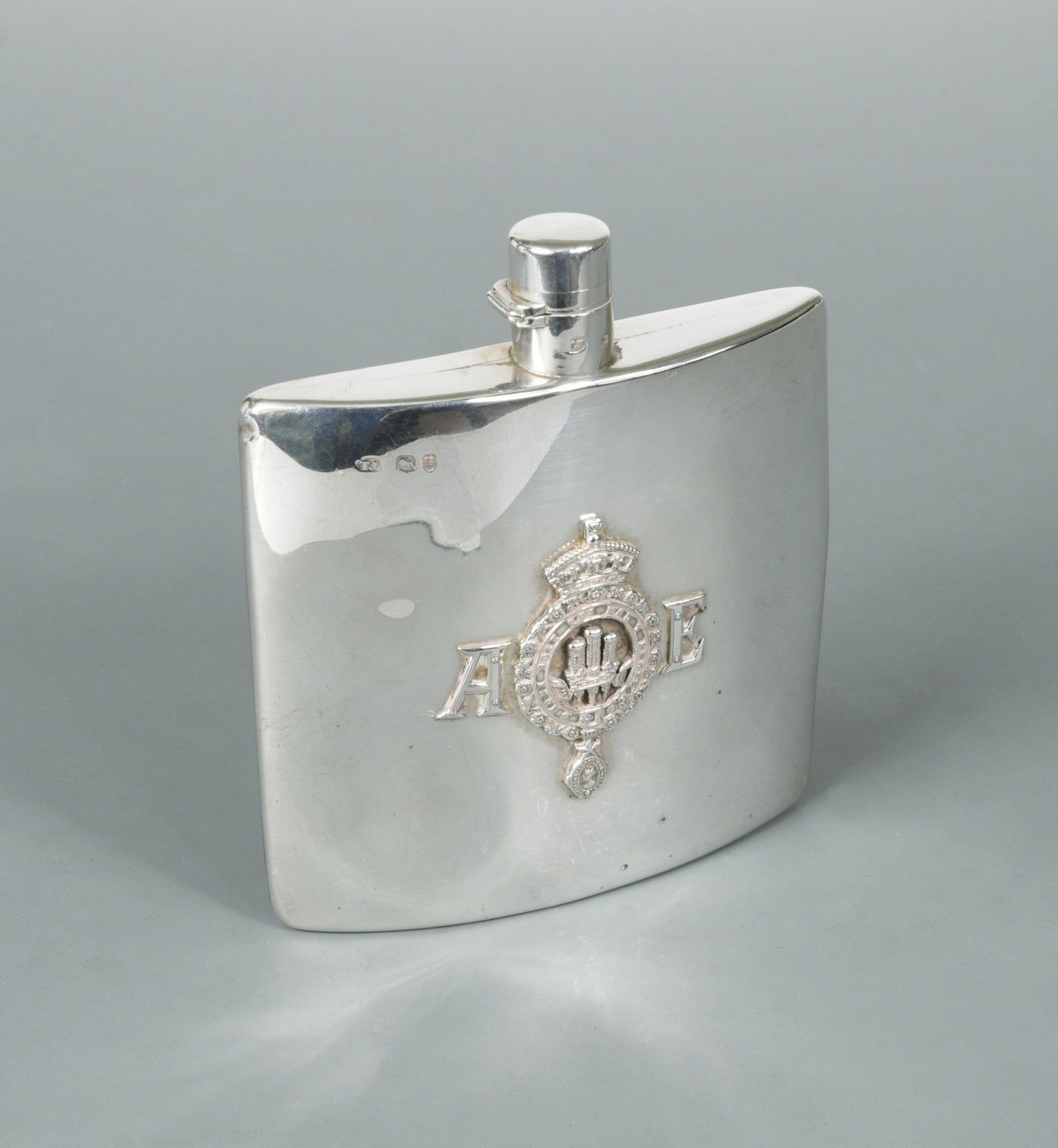 A Victorian silver spirit flask, a gift from H.R.H.: by Thomas Johnson I, London 1875, of square and slightly convex form, the front with an applied Coat of Arms of the Prince of Wales, between initials 'A' and 'E', the reverse with engraved message 'Ar