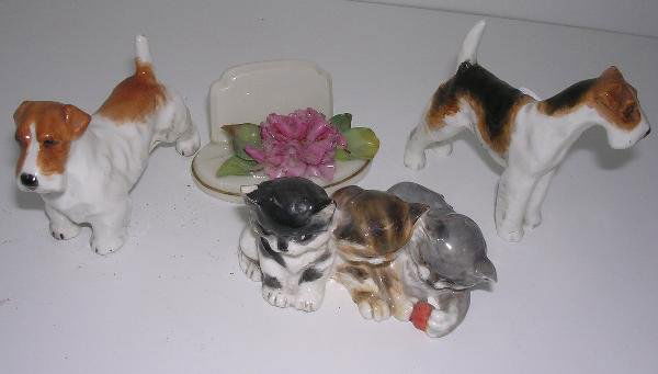 FOUR WORCESTER WARES: Three 1930's Worcester animals and a menu holder, to include: two terriers and a group of three kittens by Doris Lindner, the largest 7.5cm wide, the carnation menu holder by Antonio Vassalo, 7cm wide