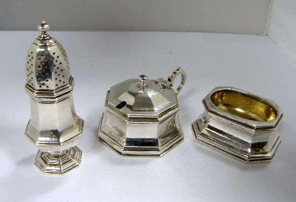 A SILVER QUEEN ANNE STYLE CRUET: A silver Queen Anne style three piece cruet by Richard Comyns, London 1968, comprising: a mustard of plain rectangular form, the body tapered over a moulded foot, having a hinged cover and scroll hand