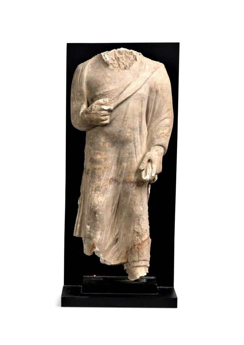 A Gandharan large stucco torso of a Buddhist follower, 3rd-5th century,: A Gandharan large stucco torso of a Buddhist follower, 3rd-5th century, standing in robes 56cm