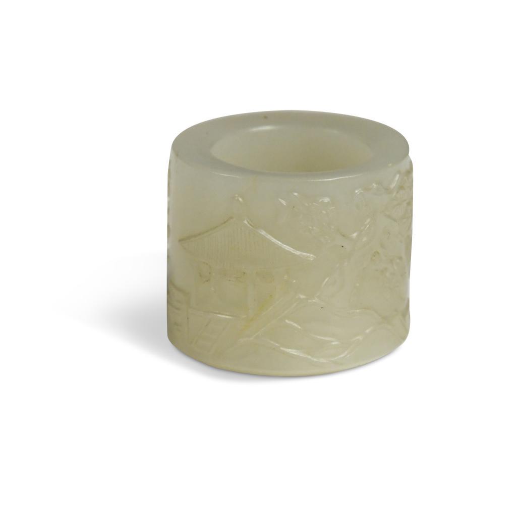 A Chinese mutton fat jade archer's ring, Qing Dynasty, 18/19th century,: A Chinese mutton fat jade archer's ring, Qing Dynasty, 18/19th century, worked in relief with a tea pavilion near a flowering prunus tree and six rows of calligraphy 2.7cm high x 3cm diameter