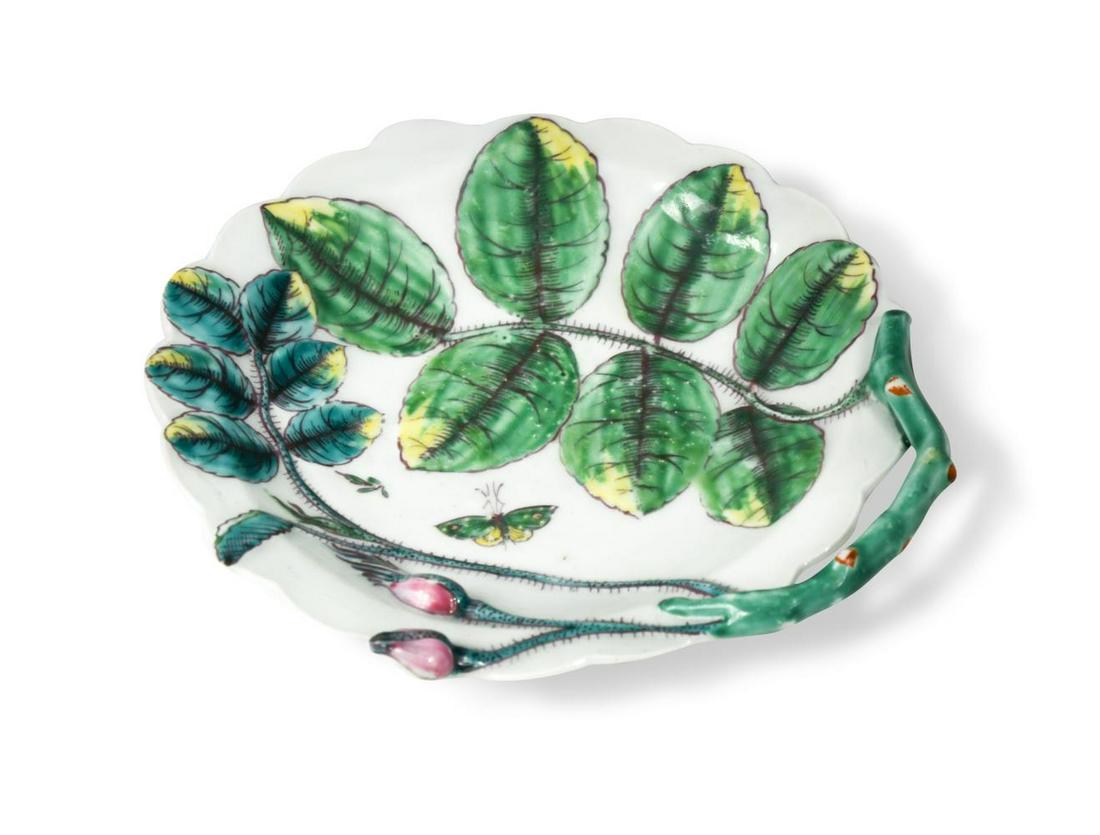 A Worcester 'Blind Earl' sweetmeat dish, circa 1758,: A Worcester 'Blind Earl' sweetmeat dish, circa 1758, of circular scalloped form, the gnarled twig handle issuing leaves and rose buds, the raised moulding picked out in tones of green, yellow and pink