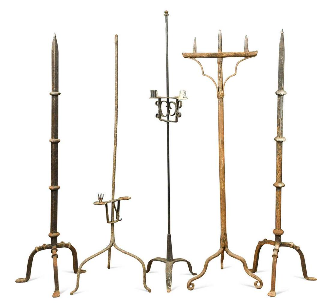 Five wrought iron candle stands,: Five wrought iron candle stands, including a pair with knopped stems and spike tops, and two with adjustable fittings, all on tripod bases, largest 134cm high Provenance: Collection of Mike Handford, 