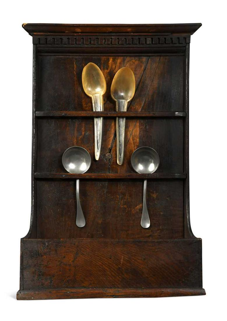 A George III oak spoon rack,: A George III oak spoon rack, the dental moulded cornice over a boarded back with two rails each with six spoon apertures above an open boxed base 58 x 39 x 13cm
