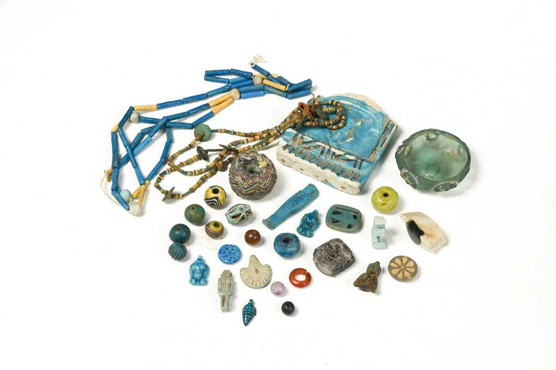 A group of Egyptian amulets,: A group of Egyptian amulets, and other items, to include Ubjat eye, a glass sarcophagus eye, a glass bowl, four part turquoise glass necklace and other items Provenance: Collection of Herbert Warner a