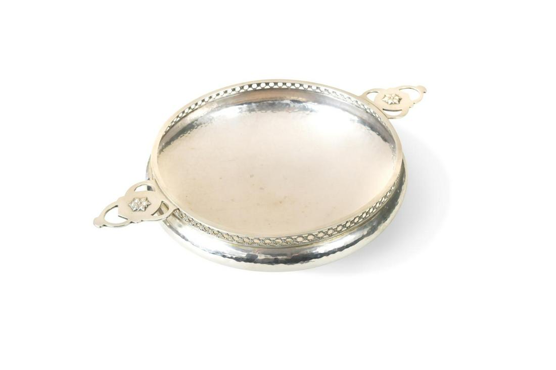 A George V silver ‘Arts & Crafts’ style dish, mark of A.E. Jones,: A George V silver ‘Arts & Crafts’ style dish, mark of A.E. Jones, Birmingham 1919, of circular and rather convex form with hammered finish, decoratively pierced rim and 2 applied and pierc