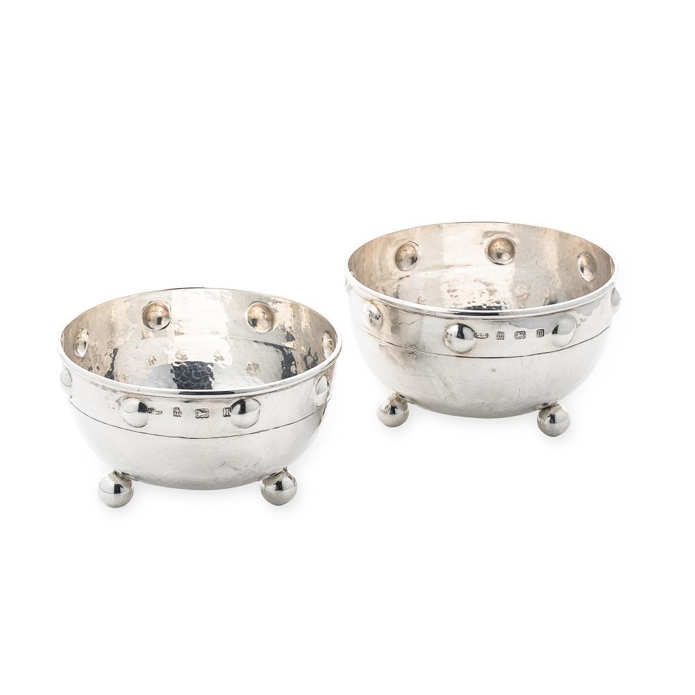 A pair of George V silver â€˜Arts & Craftsâ€™ style bowls, mark of A.E. Jones,: A pair of George V silver â€˜Arts & Craftsâ€™ style bowls, mark of A.E. Jones, Birmingham 1910/11, each of cauldron shaped form with hammered finish, turned rim above a band of â€˜rivet h