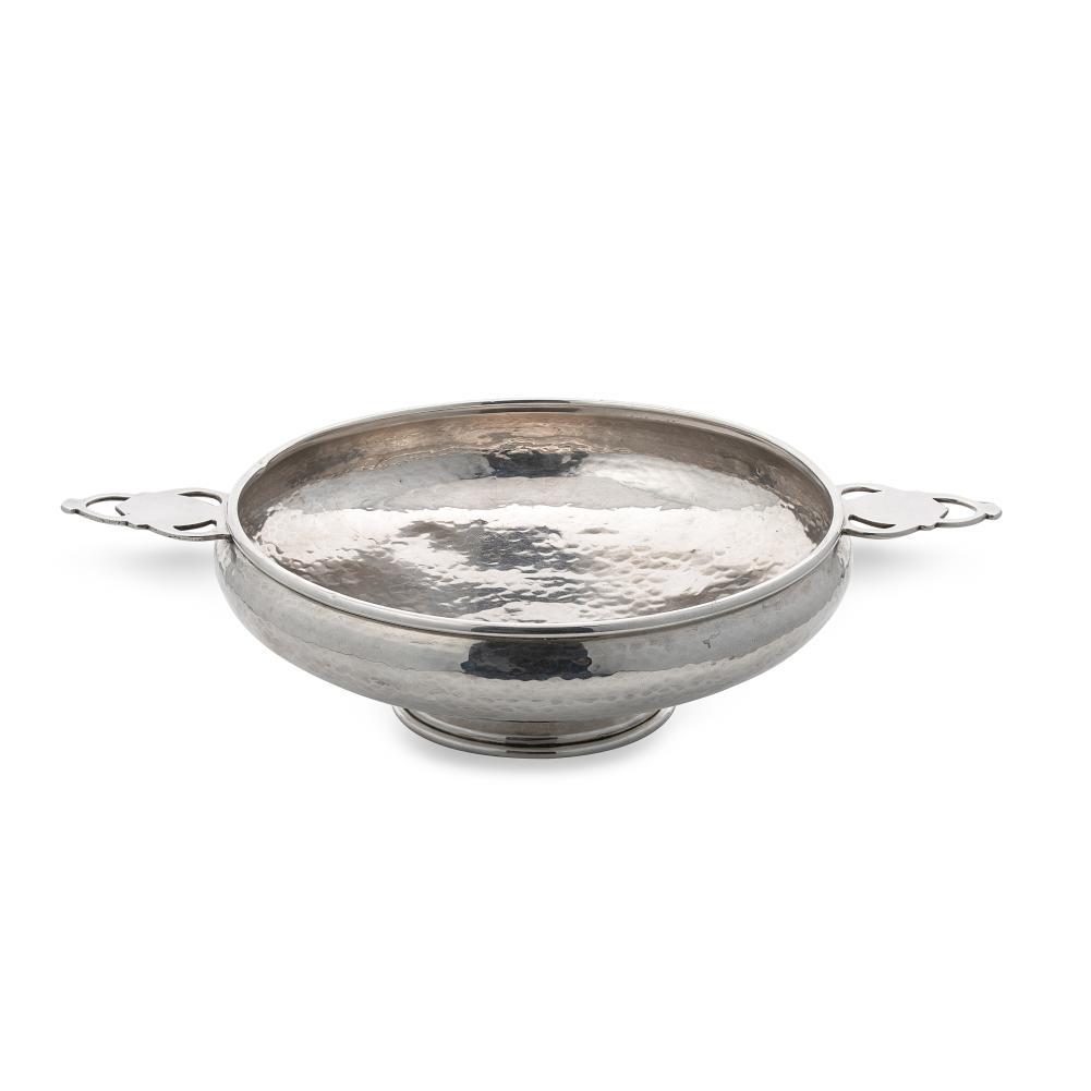 A George V silver ‘Arts & Crafts’ style dish, mark of A.E. Jones,: A George V silver ‘Arts & Crafts’ style dish, mark of A.E. Jones, Birmingham 1923, of circular and rather convex form with hammered finish, turned rim and 2 applied and pierced lug handles