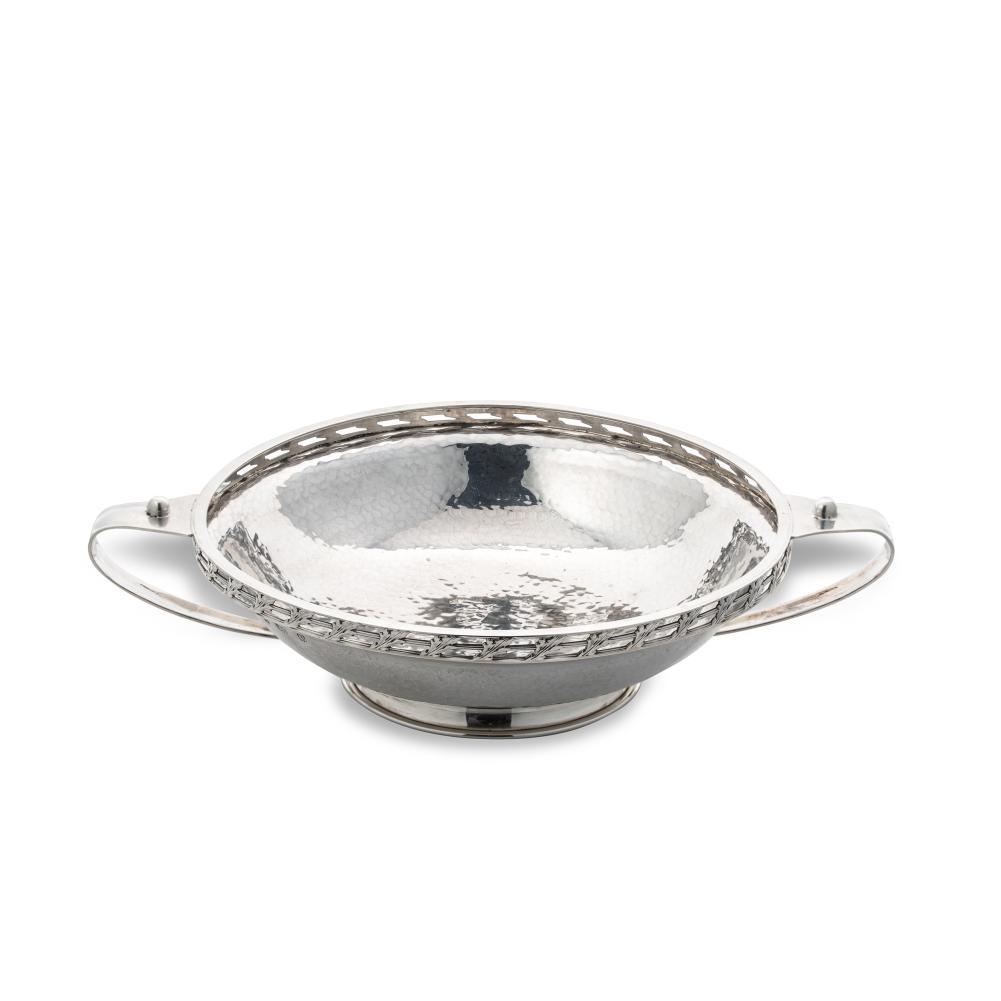 A George V silver ‘Arts & Crafts’ style dish, mark of A.E. Jones,: A George V silver ‘Arts & Crafts’ style dish, mark of A.E. Jones, Birmingham 1914, of circular, shallow and rather convex form with hammered finish and decoratively pierced rim, 2 applied