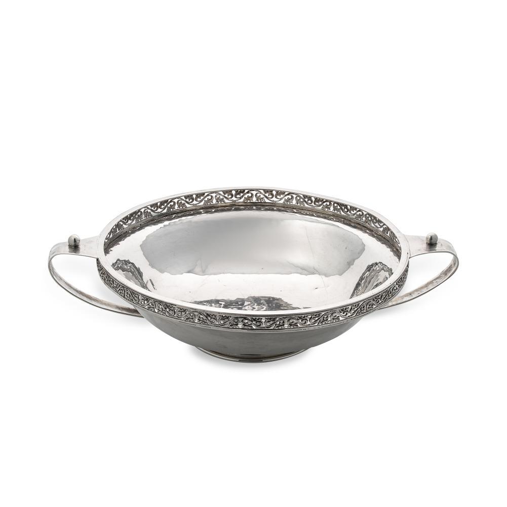 A George V silver ‘Arts & Crafts’ style silver dish, mark of A.E. Jones,: A George V silver ‘Arts & Crafts’ style silver dish, mark of A.E. Jones, Birmingham 1921, of circular and rather convex form with hammered finish, and decoratively pierced rim, 2 loop hand