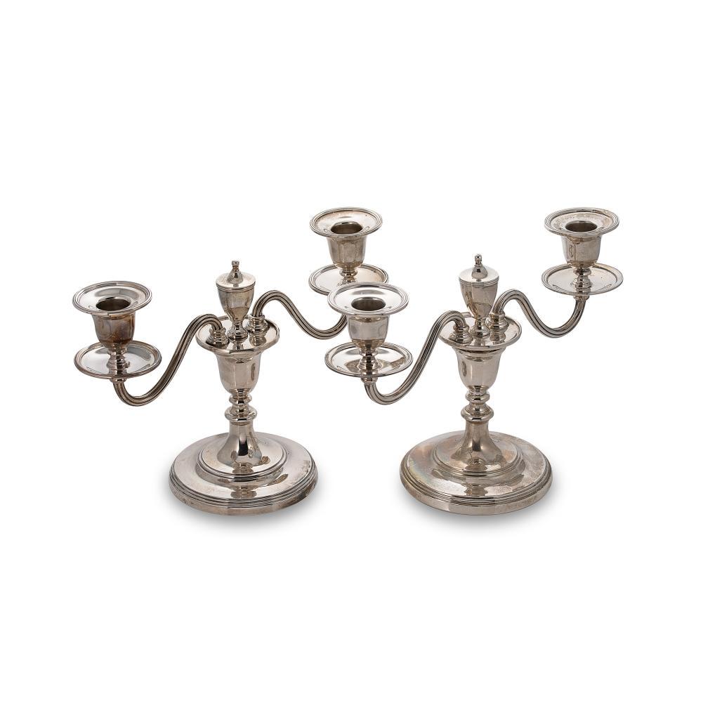 A visual pair of Elizabeth II silver two light metamorphic candelabra,: A visual pair of Elizabeth II silver two light metamorphic candelabra, mark of William Comyns & Sons Ltd. (Richard Comyns), London, each with circular fluted and stepped base (1957/1958) and part mark